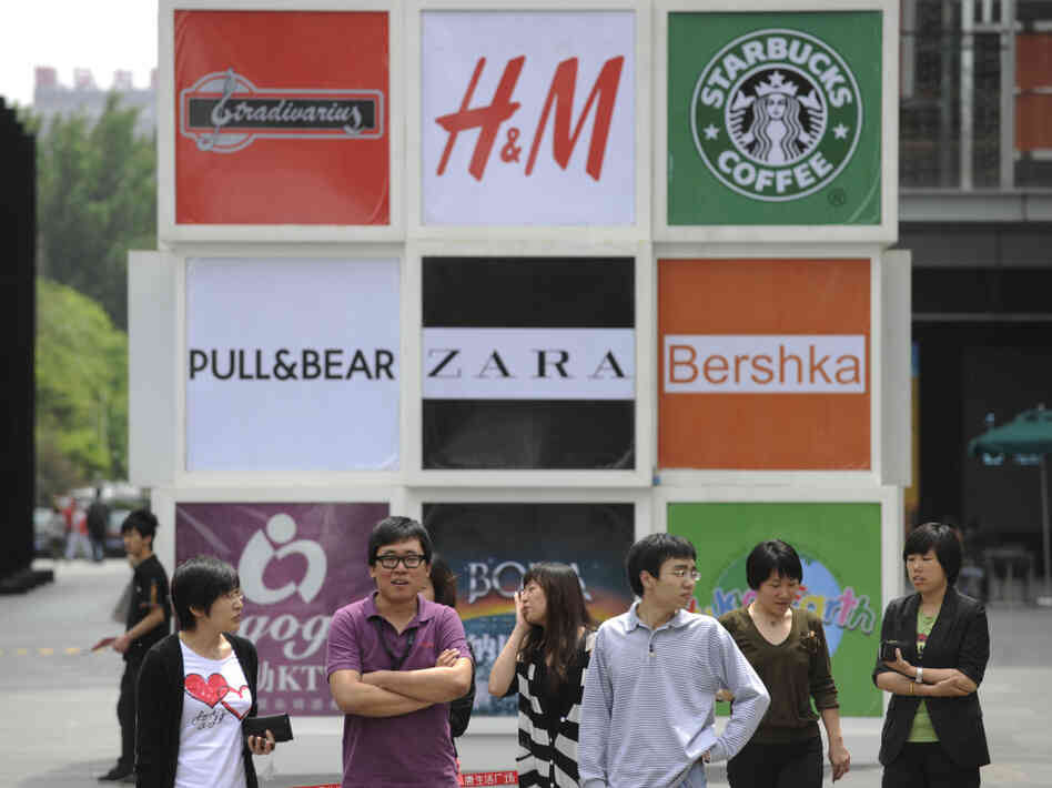 Commuters stand in front of billboards outside a shopping mall in Beijing. Brand logos are a common sight in China — but not for homegrown companies. Commuters stand in front of billboards outside a shopping mall in Beijing. Brand logos are a common sight in China — but not for homegrown companies.